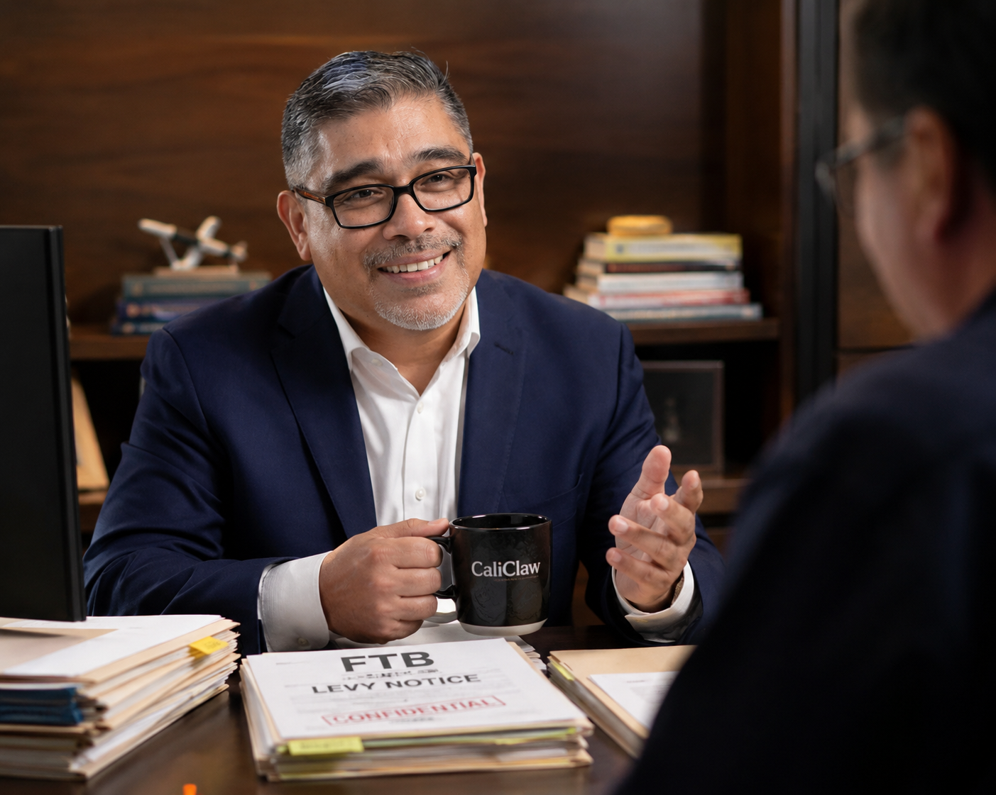 Carlos Samaniego, EA, NTPI Fellow — instructor of CaliClaw Defense, at his desk with an FTB Levy Notice file.